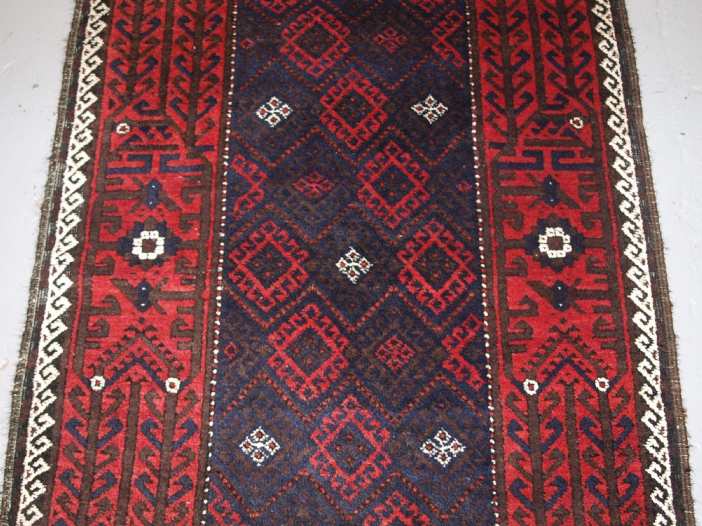 OLD AFGHAN BALUCH RUG WITH REPEAT DESIGN AND CLASSIC BALUCH BORDER, CIRCA 1920. View V