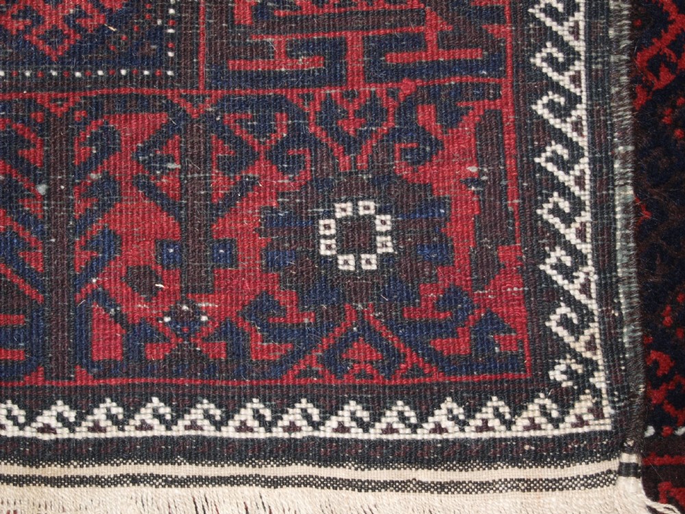 OLD AFGHAN BALUCH RUG WITH REPEAT DESIGN AND CLASSIC BALUCH BORDER, CIRCA 1920. View IX