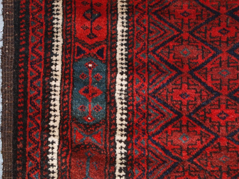 ANTIQUE BALUCH RUG WITH FINE DIAMOND LATTICE DESIGN, INTERESTING BORDER, CIRCA 1900. View IV
