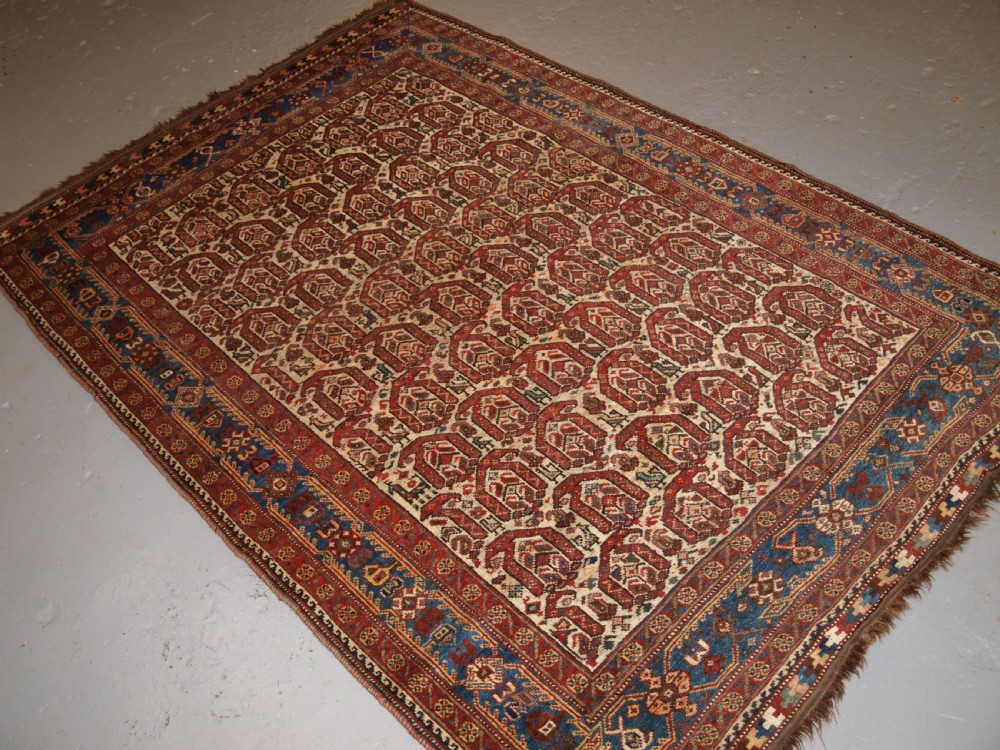 ANTIQUE RUG BY THE KHAMSEH TRIBE, ALL OVER BOTEH DESIGN ON AN IVORY FIELD, CIRCA 1900. View II