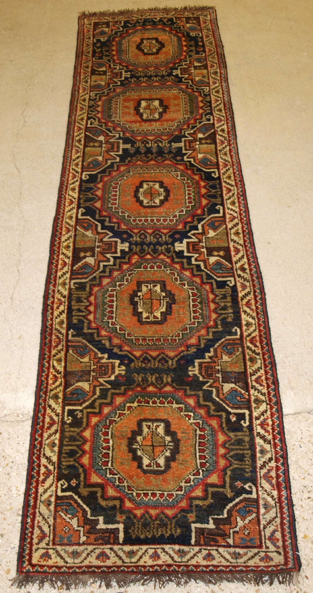 ANTIQUE PERSIAN RUNNER BY THE LURI TRIBE, UNUSUAL DESIGN WITH TURKMEN GULS, NARROW SMALL SIZE, CIRCA 1900.