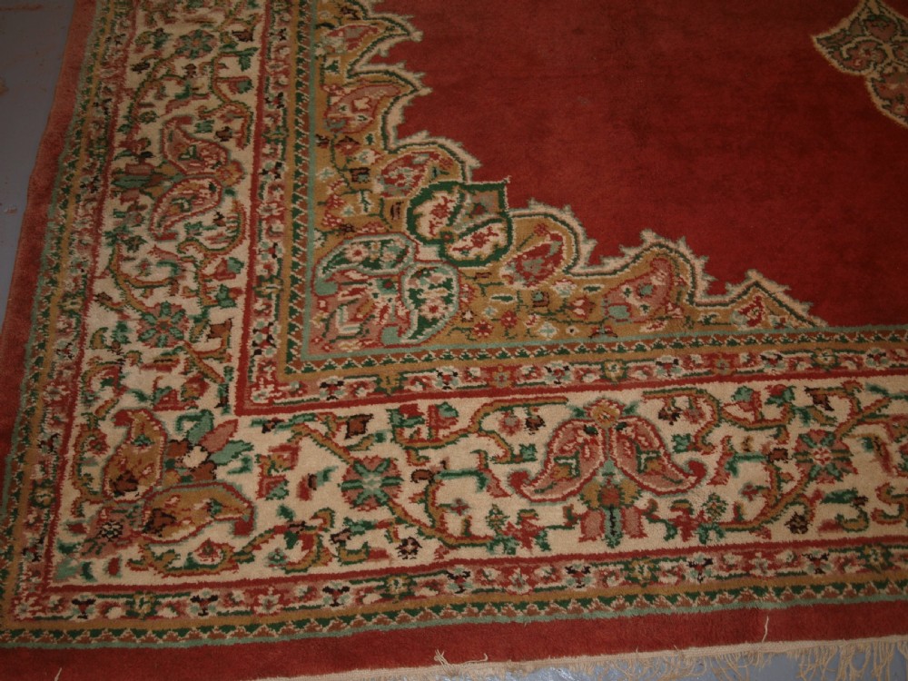 An antique Turkish Isparta wool carpet featuring a warm red field decorated with a central floral medallion and pastel borders. View VIII