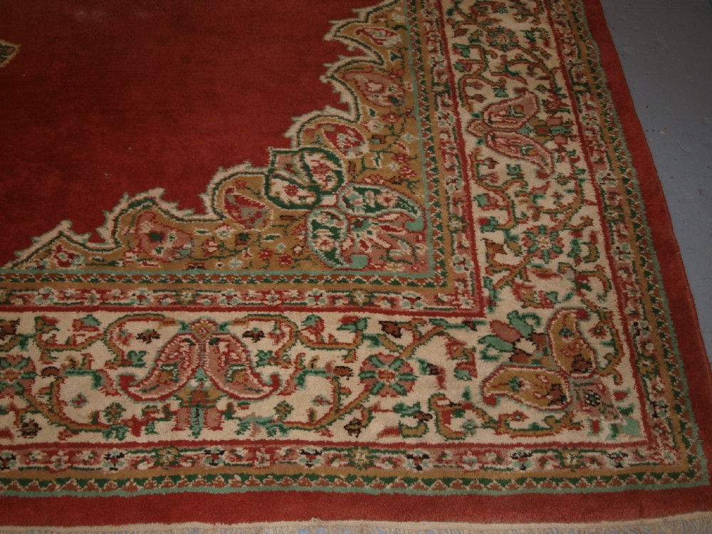 An antique Turkish Isparta wool carpet featuring a warm red field decorated with a central floral medallion and pastel borders. View XI