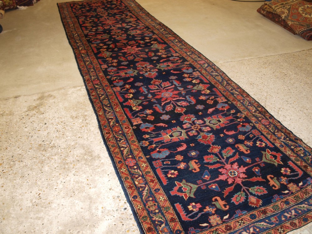 An antique Persian Hamadan wool runner featuring geometric floral patterns in red, green, and blue on a dark navy field surrounded by ornate multi-band borders. View II