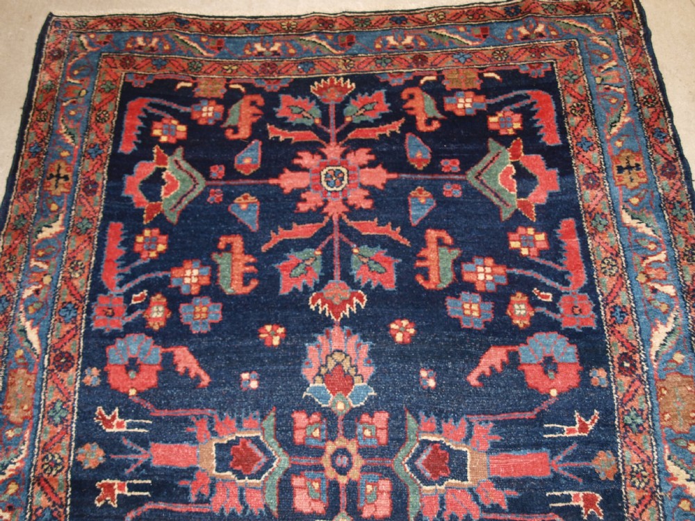 An antique Persian Hamadan wool runner featuring geometric floral patterns in red, green, and blue on a dark navy field surrounded by ornate multi-band borders. View IV