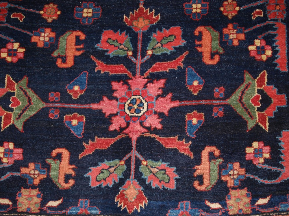 An antique Persian Hamadan wool runner featuring geometric floral patterns in red, green, and blue on a dark navy field surrounded by ornate multi-band borders. View X