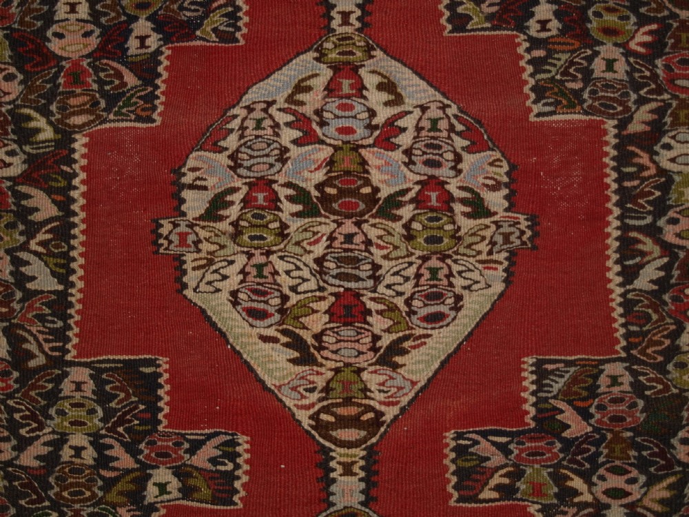 An antique Persian Senneh kilim runner featuring a sequence of linked diamond medallions on a vibrant red field with intricate geometric borders. View VIII