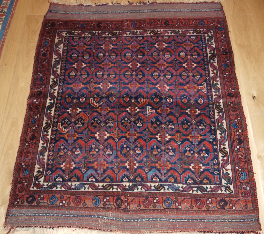 An antique hand-knotted Afshar rug featuring a repeating geometric Herati pattern in deep red, navy blue, and cream with a multi-band decorative border.