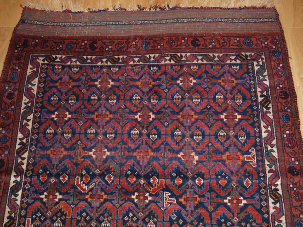 An antique hand-knotted Afshar rug featuring a repeating geometric Herati pattern in deep red, navy blue, and cream with a multi-band decorative border. View III
