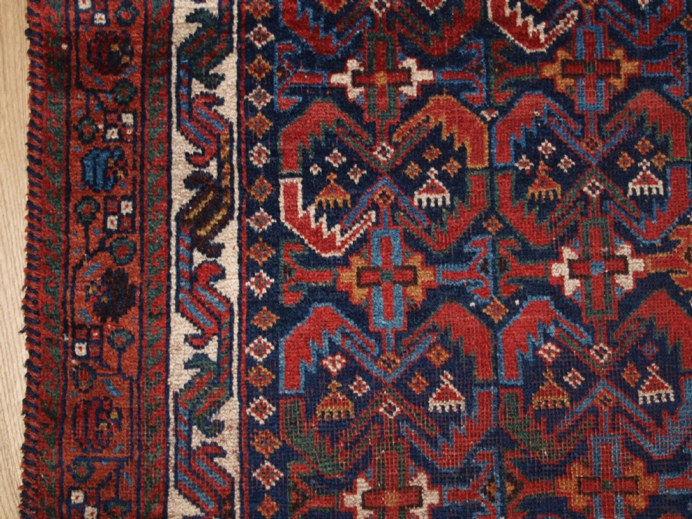 An antique hand-knotted Afshar rug featuring a repeating geometric Herati pattern in deep red, navy blue, and cream with a multi-band decorative border. View IV