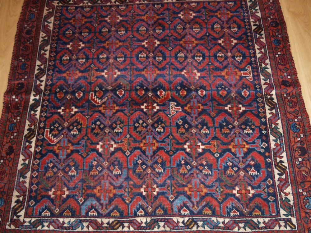 An antique hand-knotted Afshar rug featuring a repeating geometric Herati pattern in deep red, navy blue, and cream with a multi-band decorative border. View V