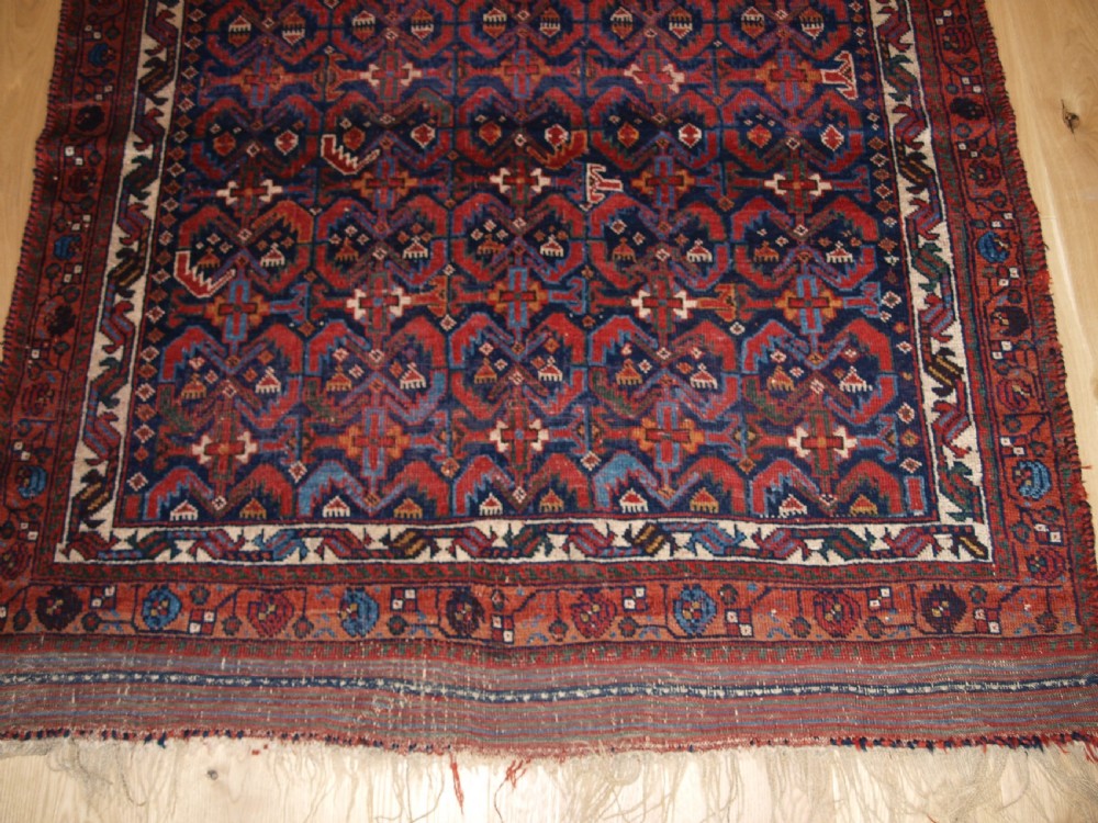 An antique hand-knotted Afshar rug featuring a repeating geometric Herati pattern in deep red, navy blue, and cream with a multi-band decorative border. View VI