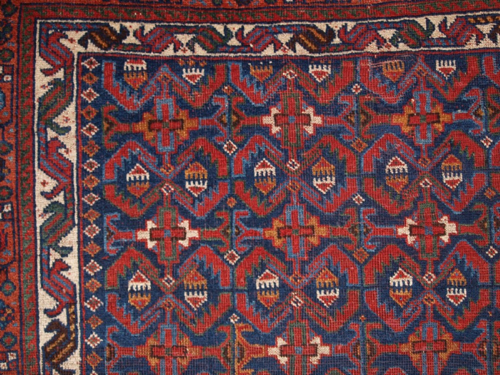 An antique hand-knotted Afshar rug featuring a repeating geometric Herati pattern in deep red, navy blue, and cream with a multi-band decorative border. View VII