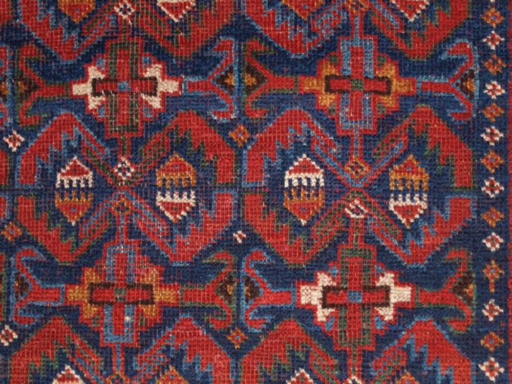 An antique hand-knotted Afshar rug featuring a repeating geometric Herati pattern in deep red, navy blue, and cream with a multi-band decorative border. View X