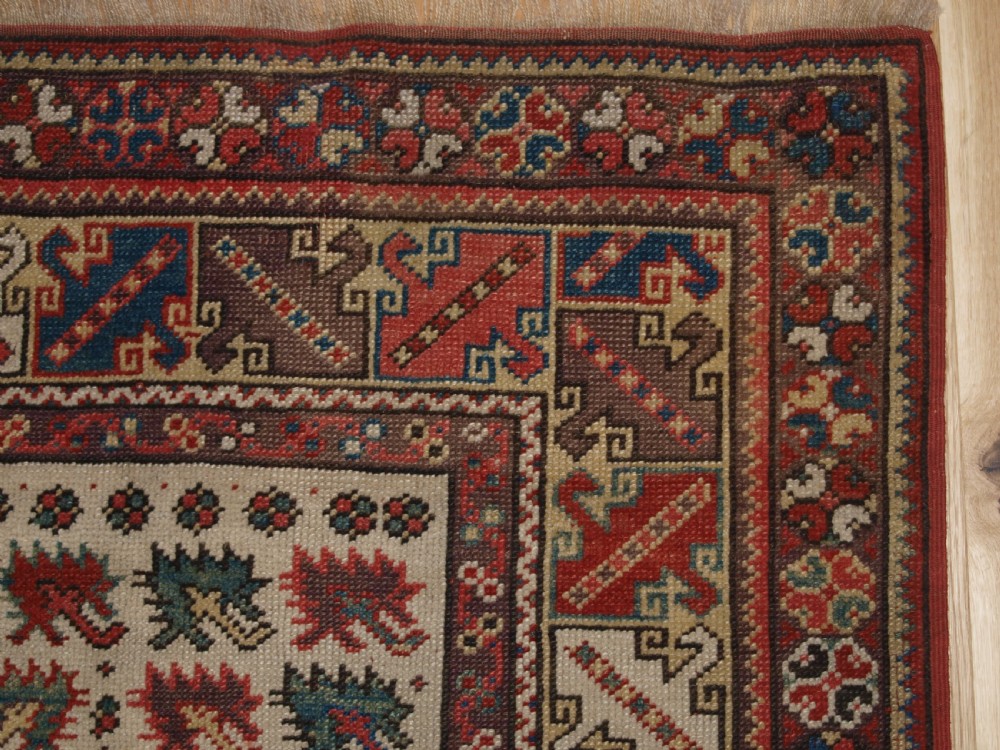 A late 19th-century Anatolian wool rug featuring a terracotta red geometric stepped mihrab niche framed by patterned multi-tiered borders in cream, blue, and red. View XI