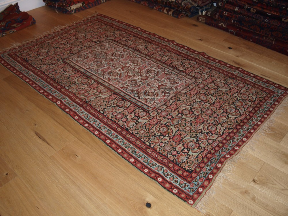 An antique flatwoven Persian Senneh kilim rug featuring a detailed central rectangle and surrounding border filled with intricate geometric and floral Herati patterns in red, ivory, and dark tones. View II