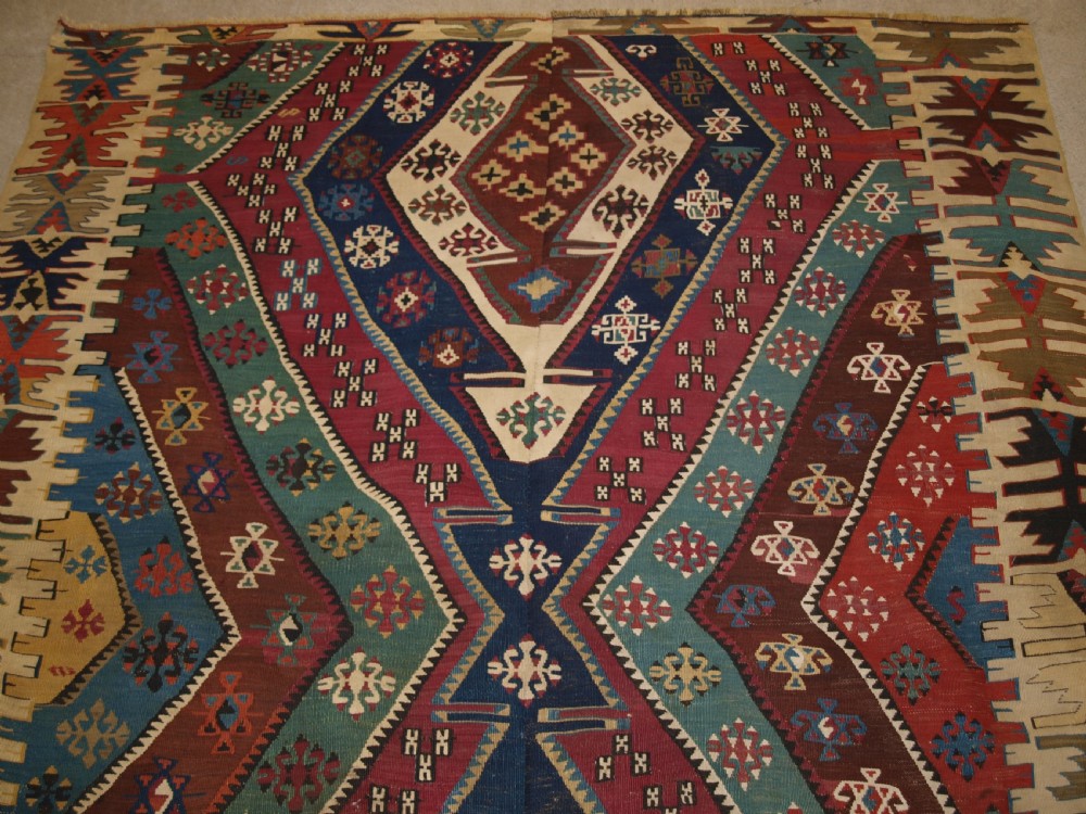 A large flatwoven late 19th-century Turkish Malatya kilim rug with central geometric diamond medallions in red, blue, green, and cream wool. View IV