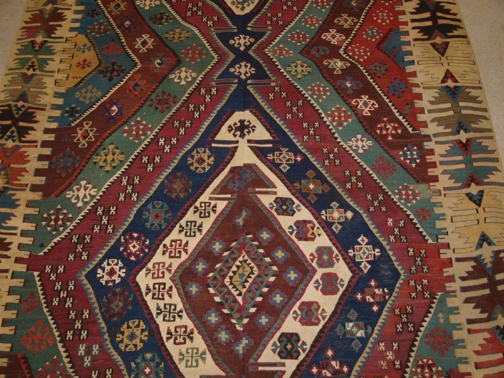 A large flatwoven late 19th-century Turkish Malatya kilim rug with central geometric diamond medallions in red, blue, green, and cream wool. View V