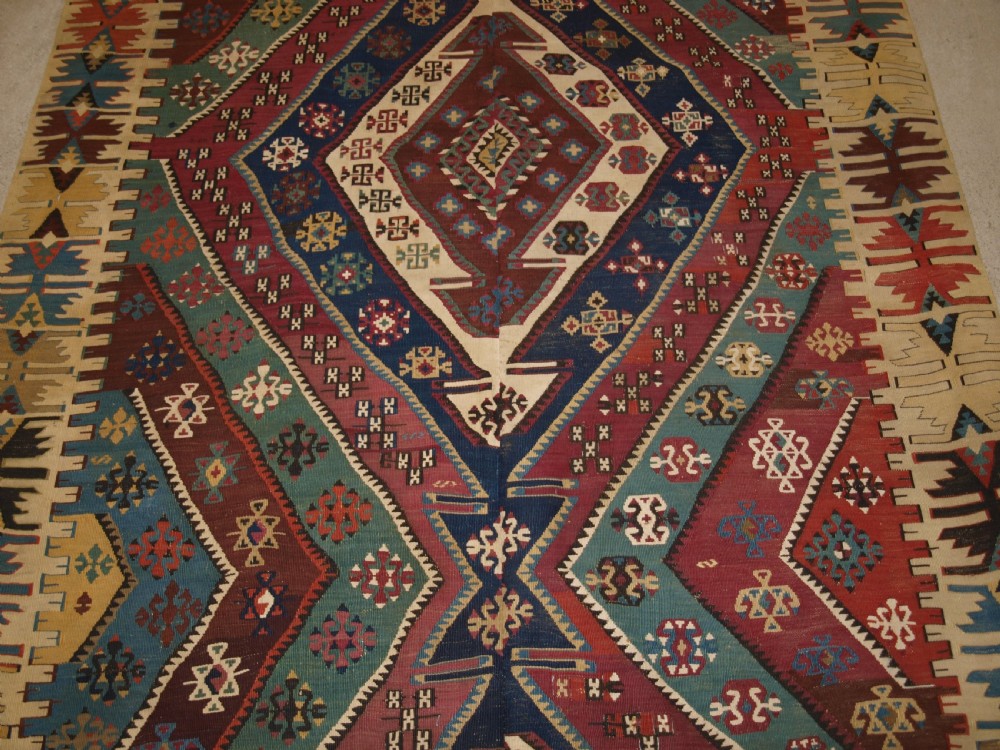 A large flatwoven late 19th-century Turkish Malatya kilim rug with central geometric diamond medallions in red, blue, green, and cream wool. View VI