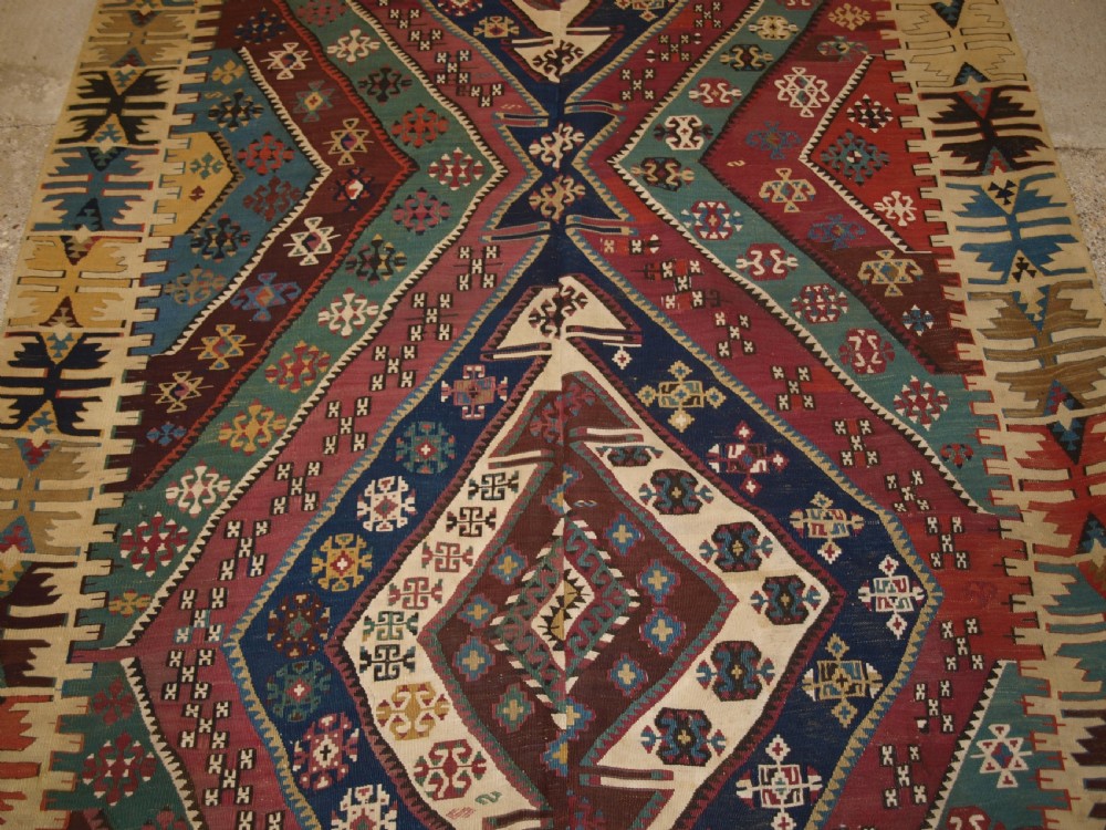 A large flatwoven late 19th-century Turkish Malatya kilim rug with central geometric diamond medallions in red, blue, green, and cream wool. View VII