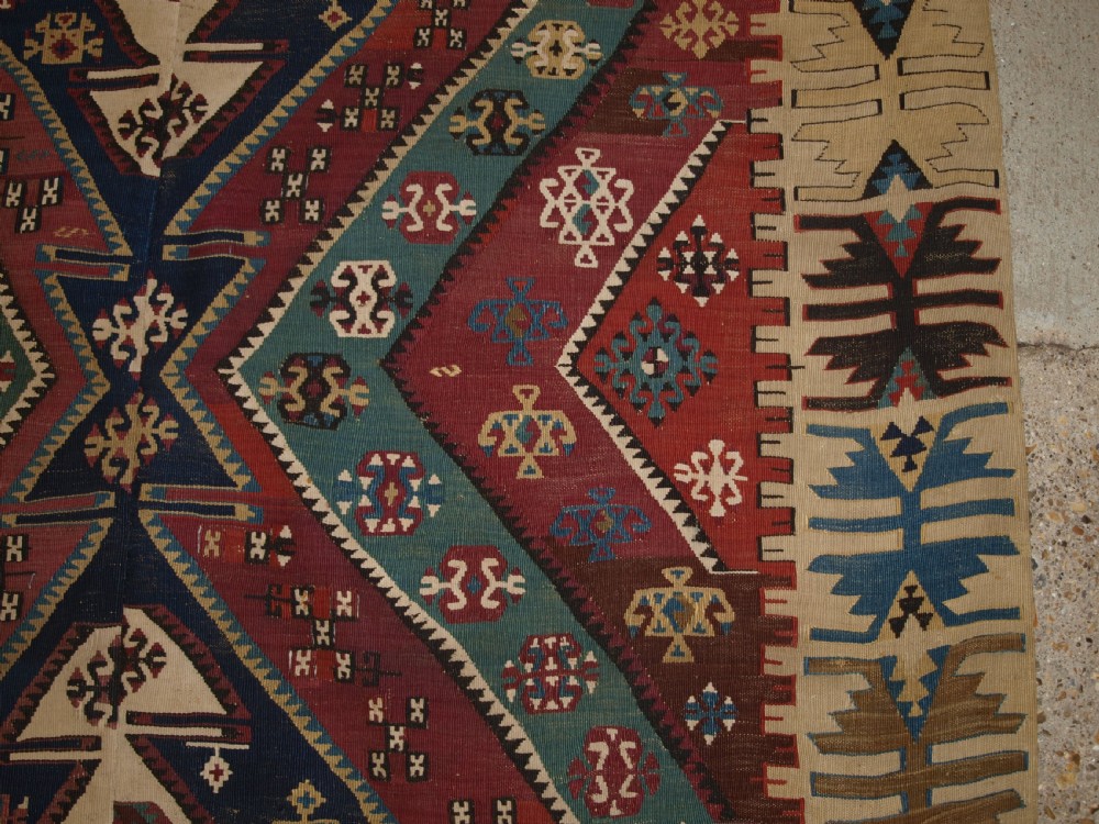 A large flatwoven late 19th-century Turkish Malatya kilim rug with central geometric diamond medallions in red, blue, green, and cream wool. View X