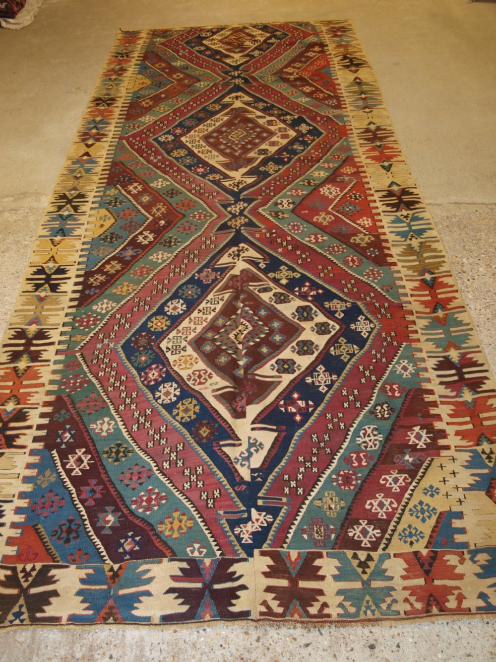 A large flatwoven late 19th-century Turkish Malatya kilim rug with central geometric diamond medallions in red, blue, green, and cream wool. View XII