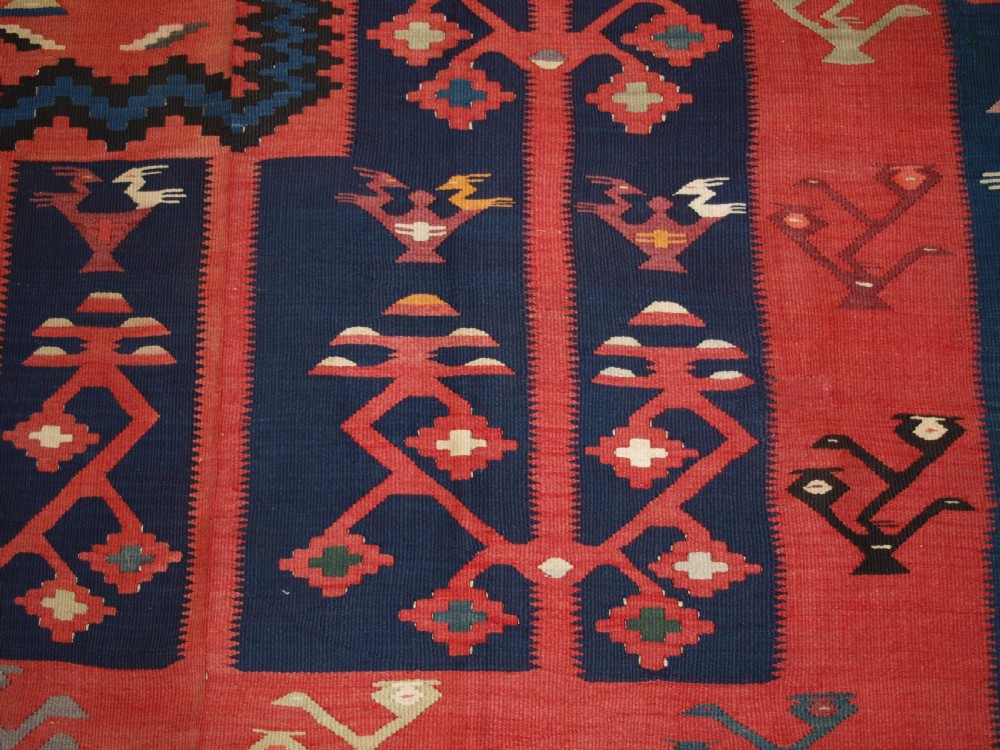 A large flatwoven Balkan Sharkoy kilim rug featuring terracotta red and navy blue borders decorated with stylised bird motifs and geometric patterns. View XV