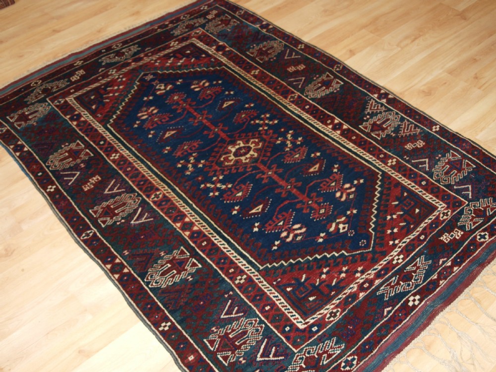 A hand-knotted Turkish Dosemealti wool rug featuring a navy blue geometric central field surrounded by deep red patterned borders. View II