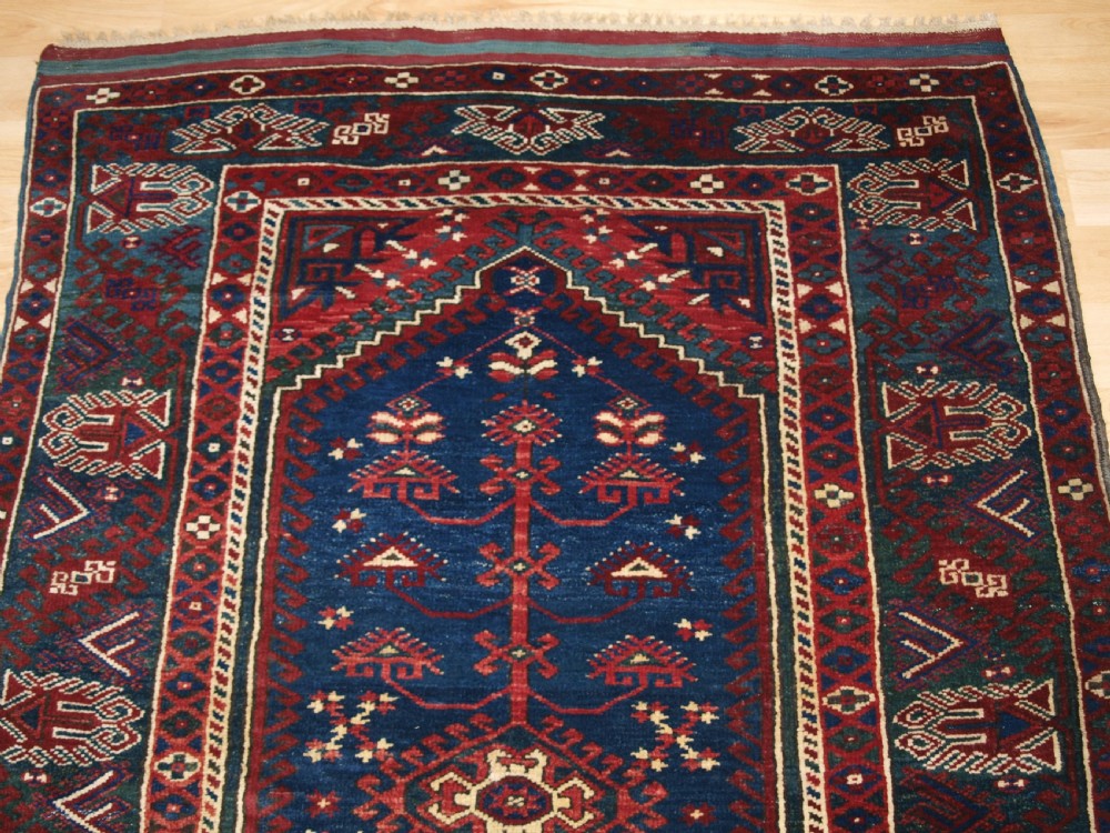 A hand-knotted Turkish Dosemealti wool rug featuring a navy blue geometric central field surrounded by deep red patterned borders. View IV