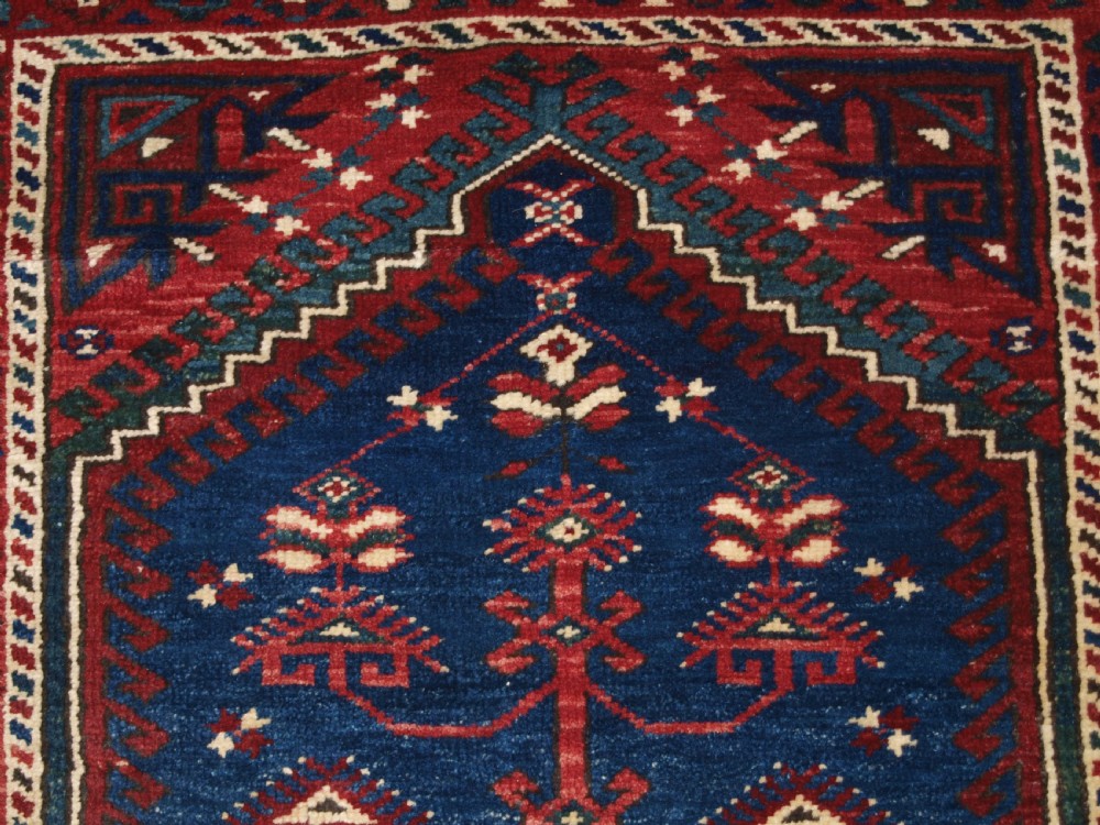 A hand-knotted Turkish Dosemealti wool rug featuring a navy blue geometric central field surrounded by deep red patterned borders. View VII