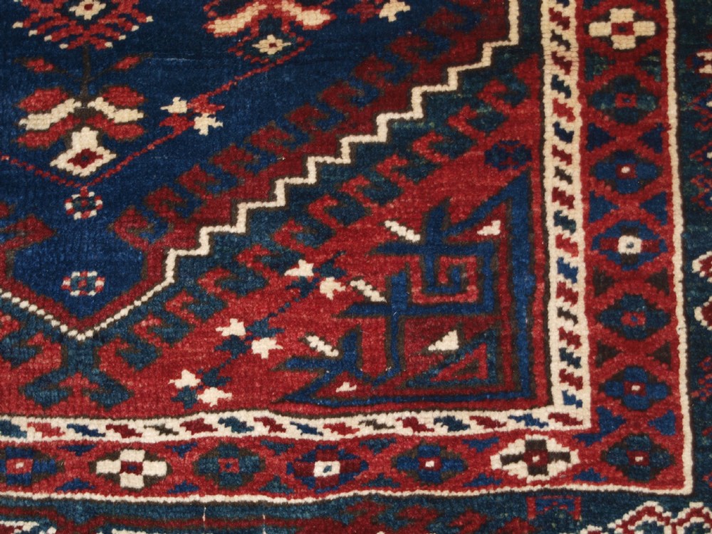 A hand-knotted Turkish Dosemealti wool rug featuring a navy blue geometric central field surrounded by deep red patterned borders. View XIII