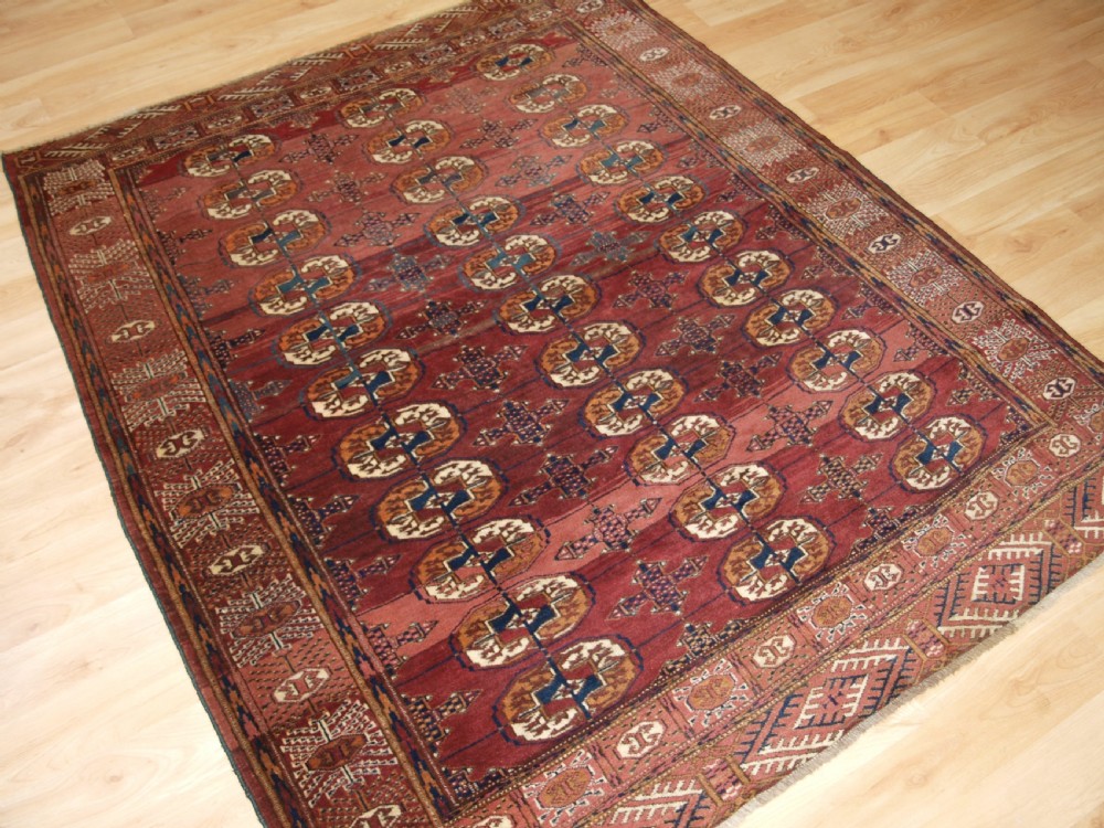 ANTIQUE TEKKE TURKMEN RUG WITH ABRASHED MADDER RED FIELD, CIRCA 1900. View II