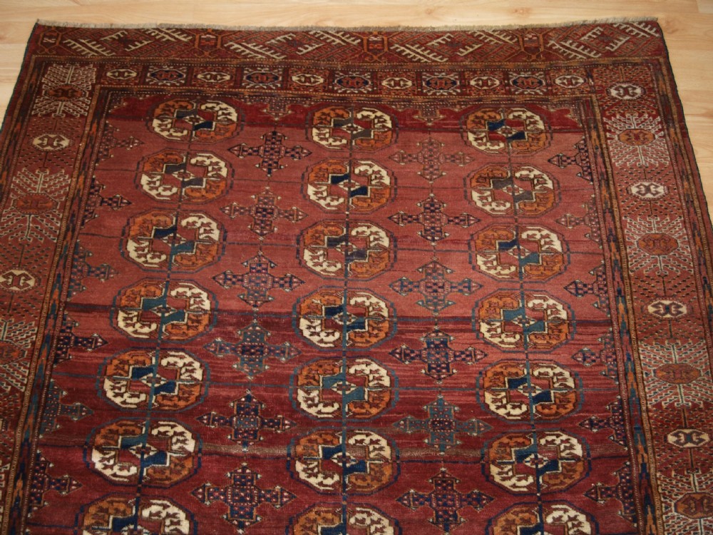 ANTIQUE TEKKE TURKMEN RUG WITH ABRASHED MADDER RED FIELD, CIRCA 1900. View IV