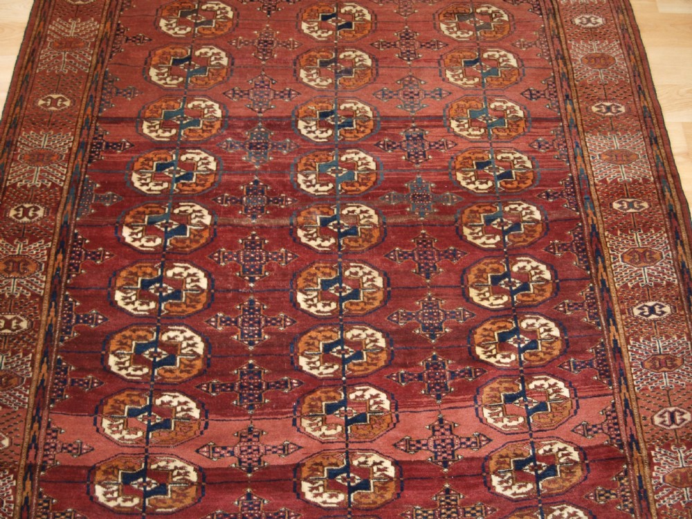 ANTIQUE TEKKE TURKMEN RUG WITH ABRASHED MADDER RED FIELD, CIRCA 1900. View V