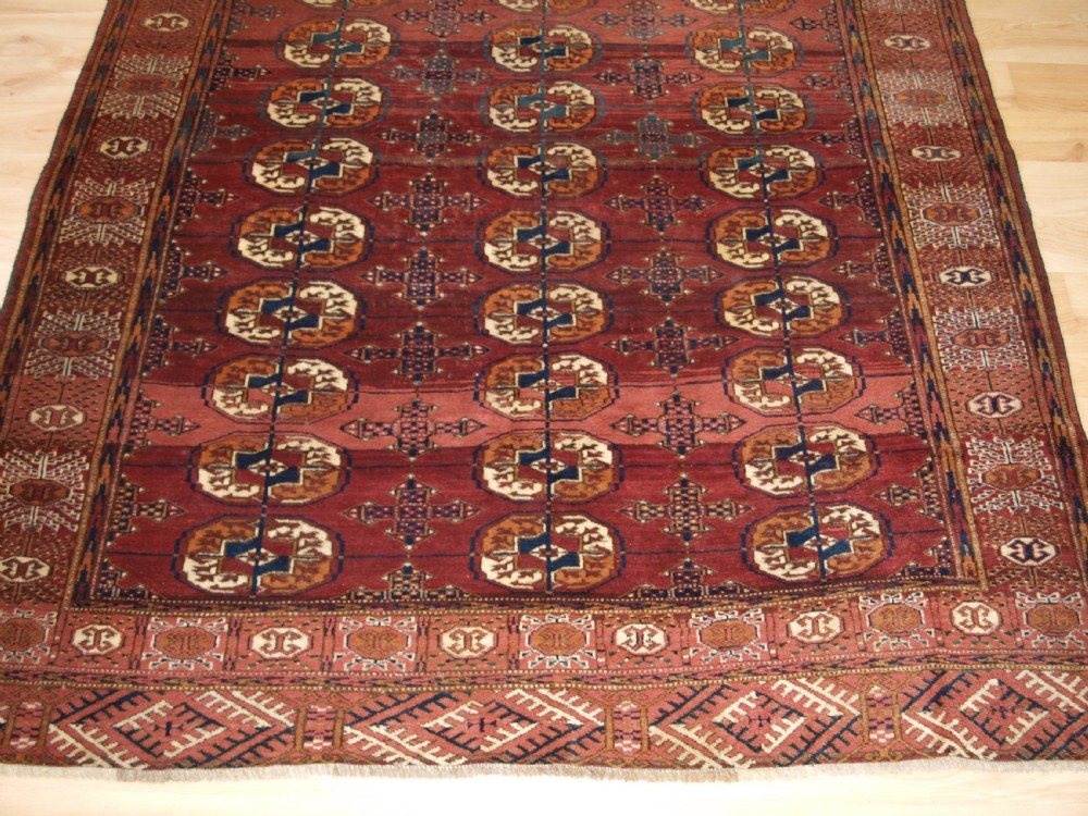 ANTIQUE TEKKE TURKMEN RUG WITH ABRASHED MADDER RED FIELD, CIRCA 1900. View VI