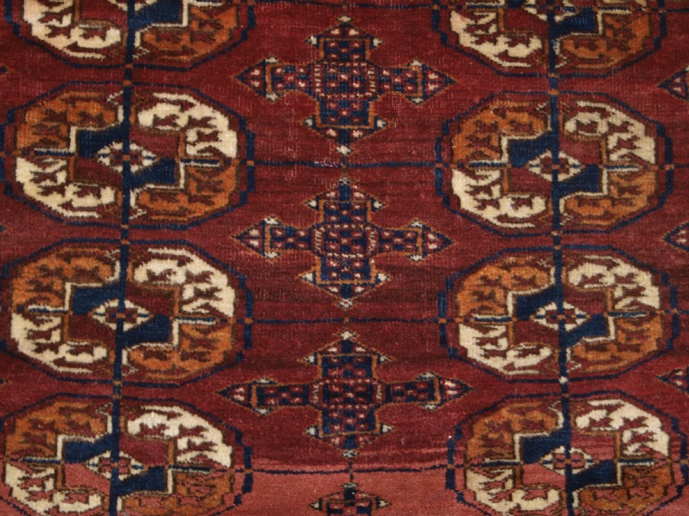 ANTIQUE TEKKE TURKMEN RUG WITH ABRASHED MADDER RED FIELD, CIRCA 1900. View VIII