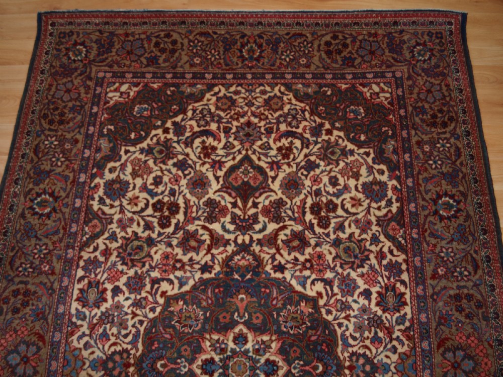 A rectangular hand-knotted Persian Tabriz wool rug with a central dark navy floral medallion on a cream field framed by multi-stripe borders. View III