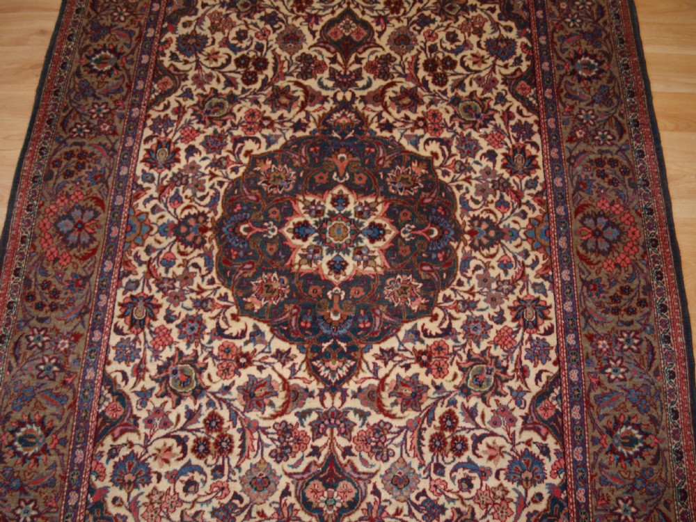 A rectangular hand-knotted Persian Tabriz wool rug with a central dark navy floral medallion on a cream field framed by multi-stripe borders. View IV