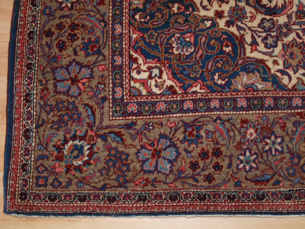 A rectangular hand-knotted Persian Tabriz wool rug with a central dark navy floral medallion on a cream field framed by multi-stripe borders. View VI