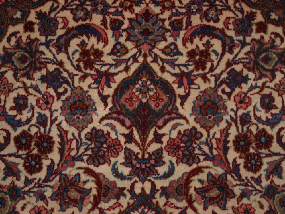 A rectangular hand-knotted Persian Tabriz wool rug with a central dark navy floral medallion on a cream field framed by multi-stripe borders. View VII