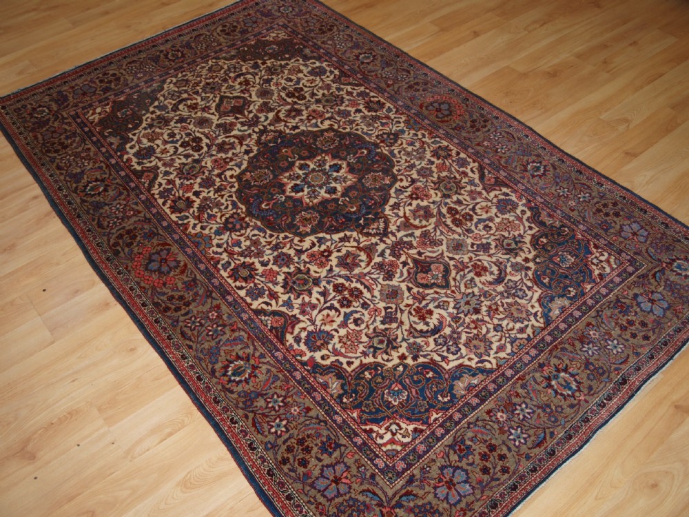 A rectangular hand-knotted Persian Tabriz wool rug with a central dark navy floral medallion on a cream field framed by multi-stripe borders. View IX