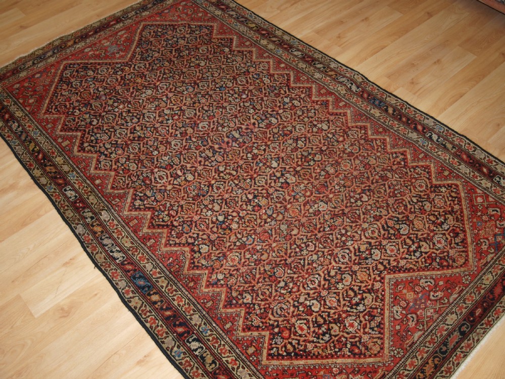 An antique hand-knotted Persian Malayer wool rug featuring an intricate red lattice pattern framed by multi-band decorative borders. View II