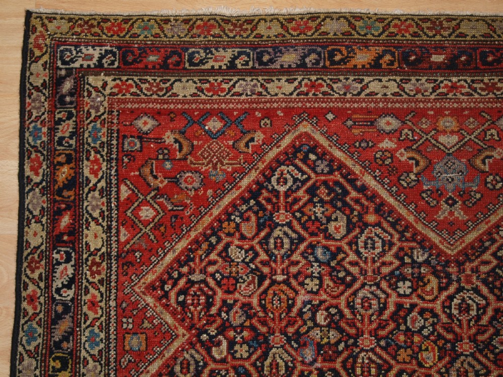 An antique hand-knotted Persian Malayer wool rug featuring an intricate red lattice pattern framed by multi-band decorative borders. View III