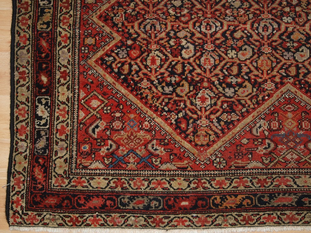 An antique hand-knotted Persian Malayer wool rug featuring an intricate red lattice pattern framed by multi-band decorative borders. View VII