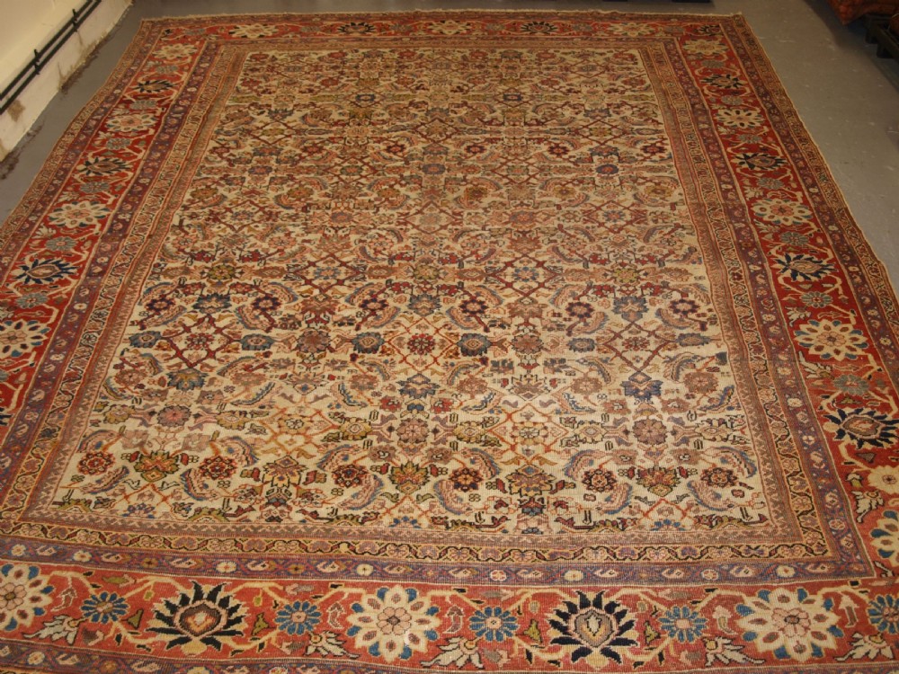 An antique Persian Mahal wool carpet featuring an all-over floral lattice pattern on an ivory ground, framed by a wide terracotta and navy border. View II