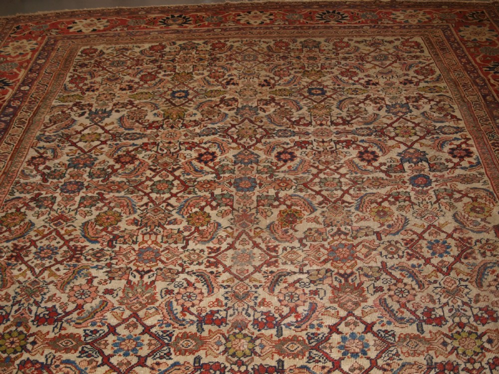 An antique Persian Mahal wool carpet featuring an all-over floral lattice pattern on an ivory ground, framed by a wide terracotta and navy border. View III
