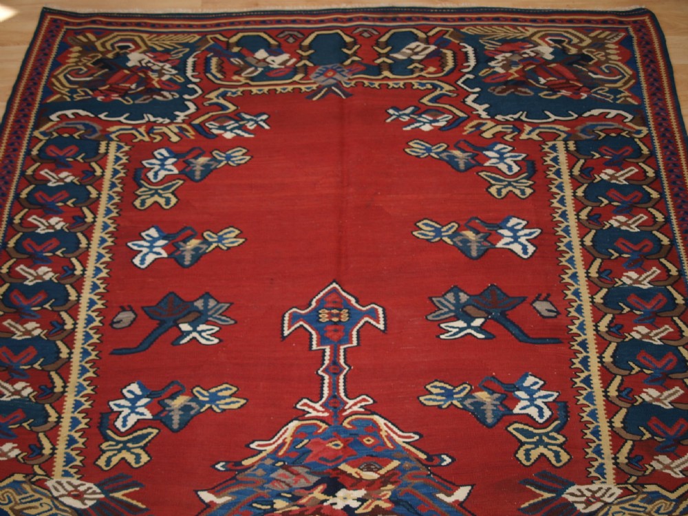 An antique Persian Bijar flatweave kilim rug featuring a deep red central field with a central geometric medallion and floral motifs surrounded by decorative borders. View VI