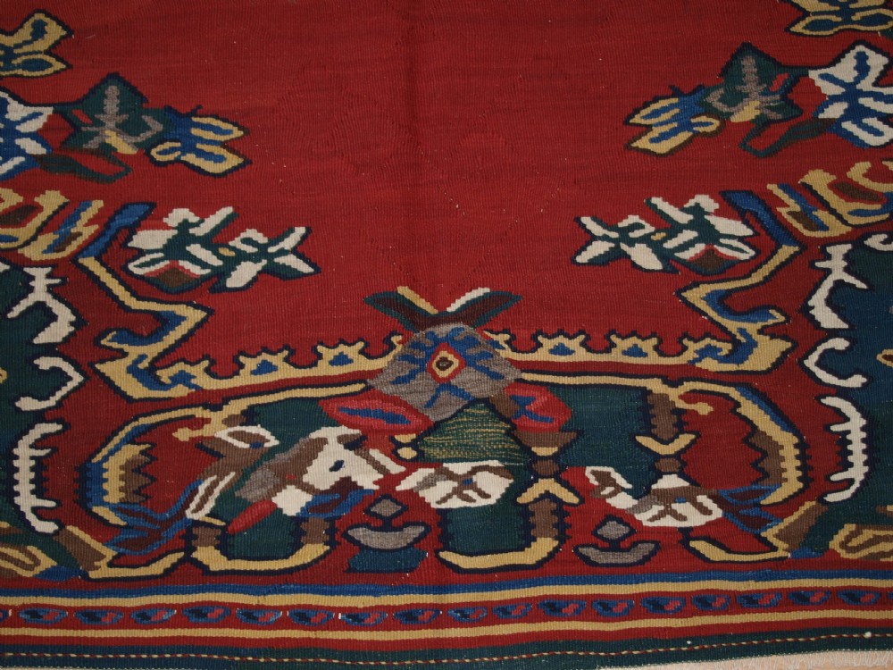 An antique Persian Bijar flatweave kilim rug featuring a deep red central field with a central geometric medallion and floral motifs surrounded by decorative borders. View VIII
