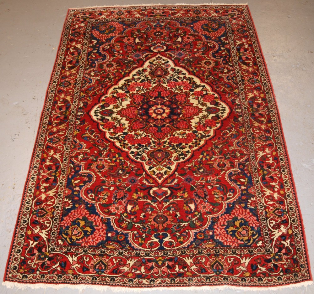 ANTIQUE PERSIAN BAKHTIARI VILLAGE RUG, FLORAL MEDALLION DESIGN, CIRCA 1920.