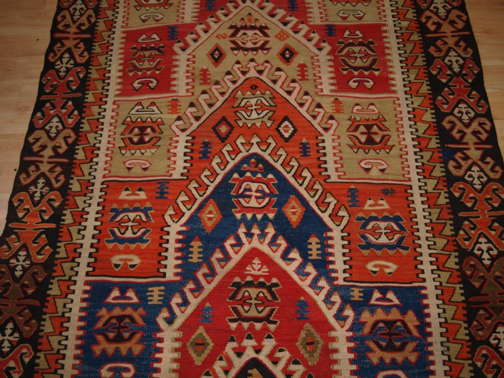 An antique Turkish Konya flatweave prayer kilim featuring a stepped mihrab pattern in red, blue, terracotta, and beige wool. View V